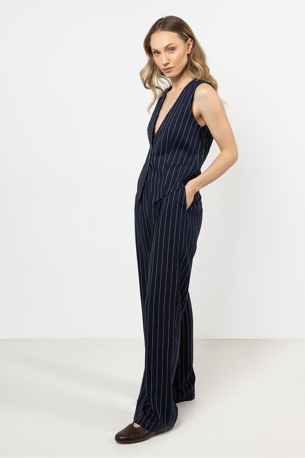 Elegant linen trousers by awama with wide legs and delicate stripes, showcasing luxury and comfort.