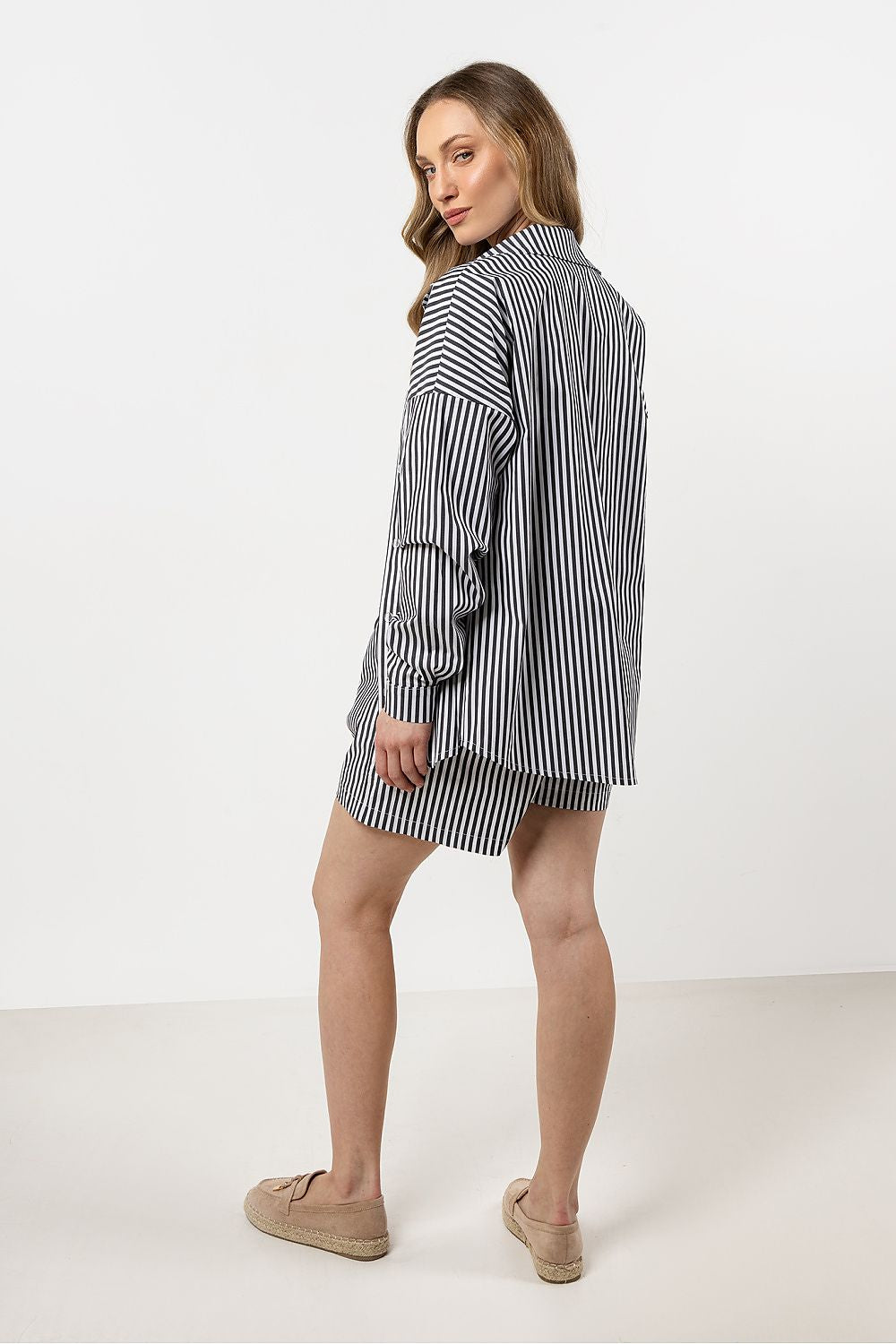 Model wearing the Awama luxury long sleeve cotton shirt, showcasing its versatility and sophisticated style for a chic summer outfit.