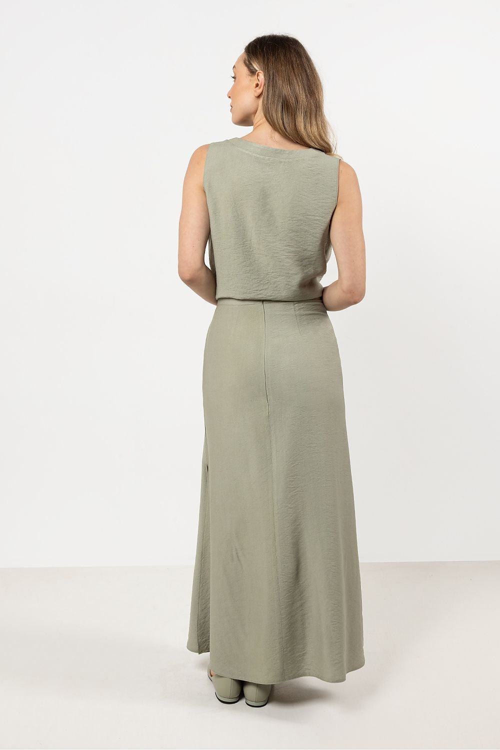 Stylish model wearing the Awama Elegant V-Neck Blouse, accentuating a flattering silhouette with a V-neckline.