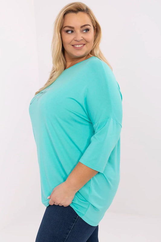 Sophisticated close-up of Relevance's plus size blouse featuring a classic round neckline and a stylish inscription adorned with sparkling jet stones.