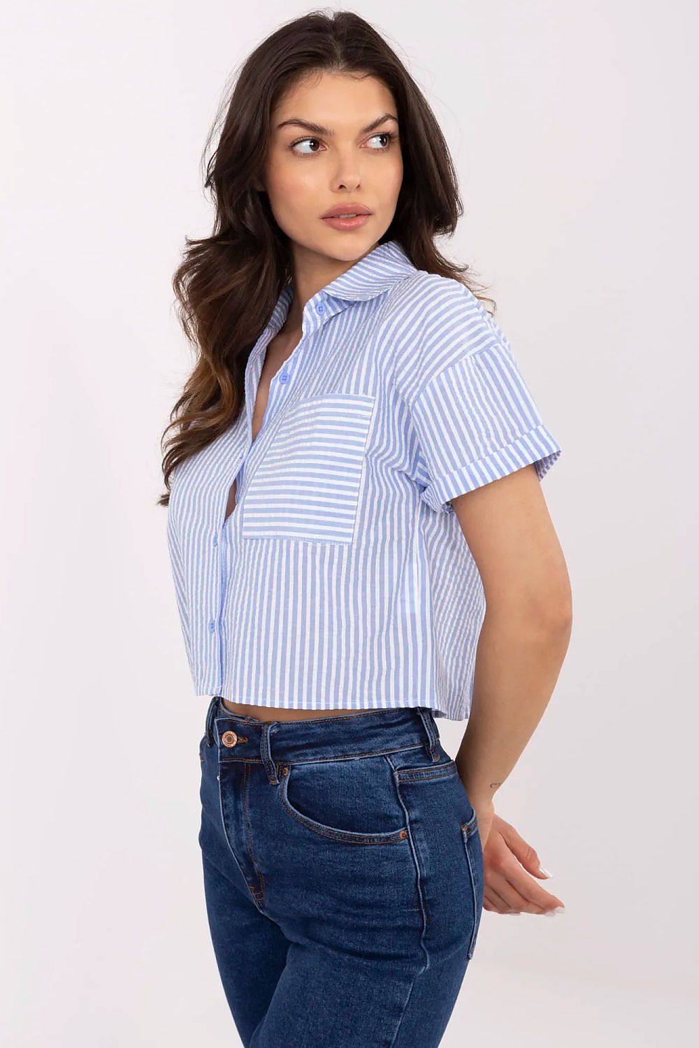 Model wearing NM's luxury striped cotton short sleeve shirt, perfect for warmer days, paired effortlessly with jeans and a skirt.