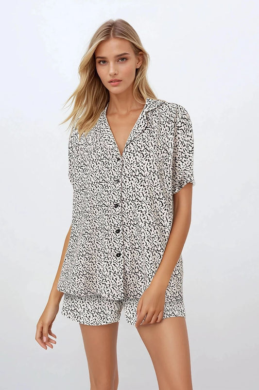 Luxury women's cotton pyjamas set by Momenti Per Me, featuring a stylish short sleeve V-neck shirt and comfortable shorts, perfect for elegant sleeping wear.