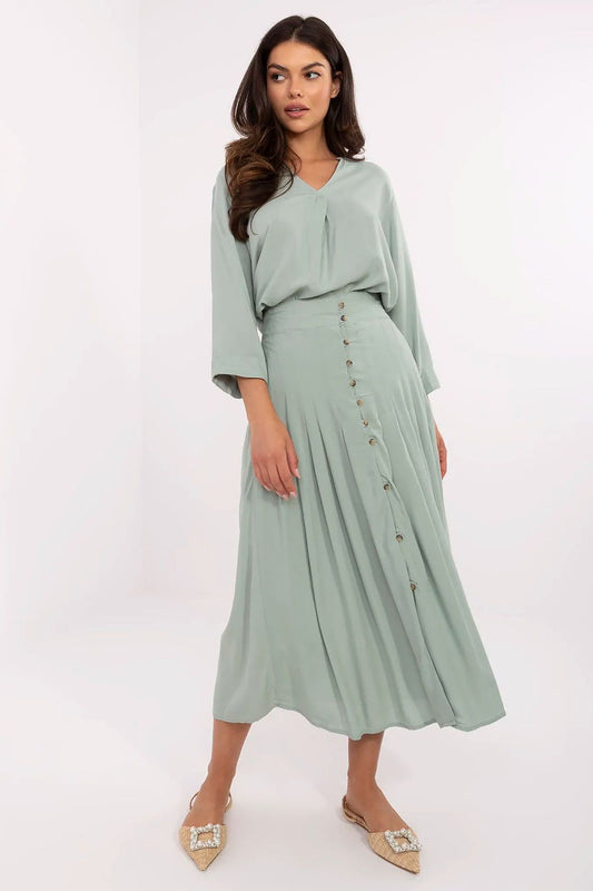Elegant pleated midi skirt by Sublevel in eco viscose, featuring decorative buttons for a touch of luxury, perfect for stylish comfort in a sophisticated wardrobe.