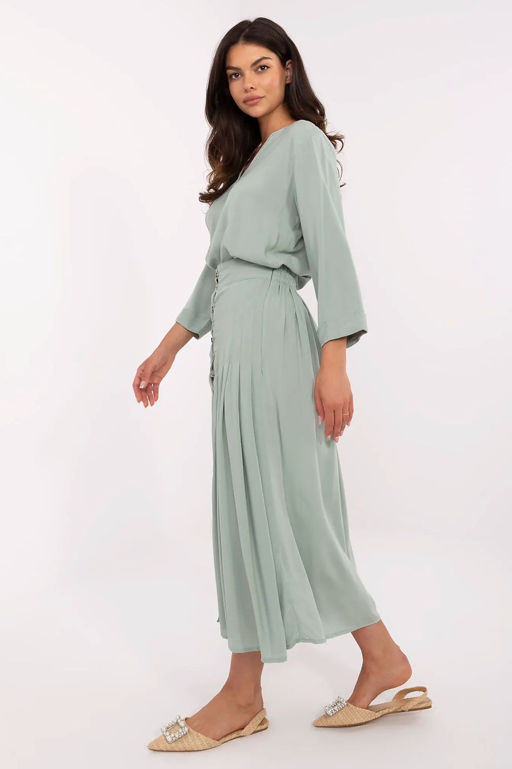 Side view of luxurious pleated midi skirt by Sublevel, showcasing eco-friendly viscose material and flattering fit, ideal for both casual and office wear.