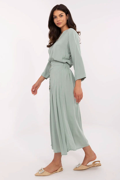 Side view of luxurious pleated midi skirt by Sublevel, showcasing eco-friendly viscose material and flattering fit, ideal for both casual and office wear.