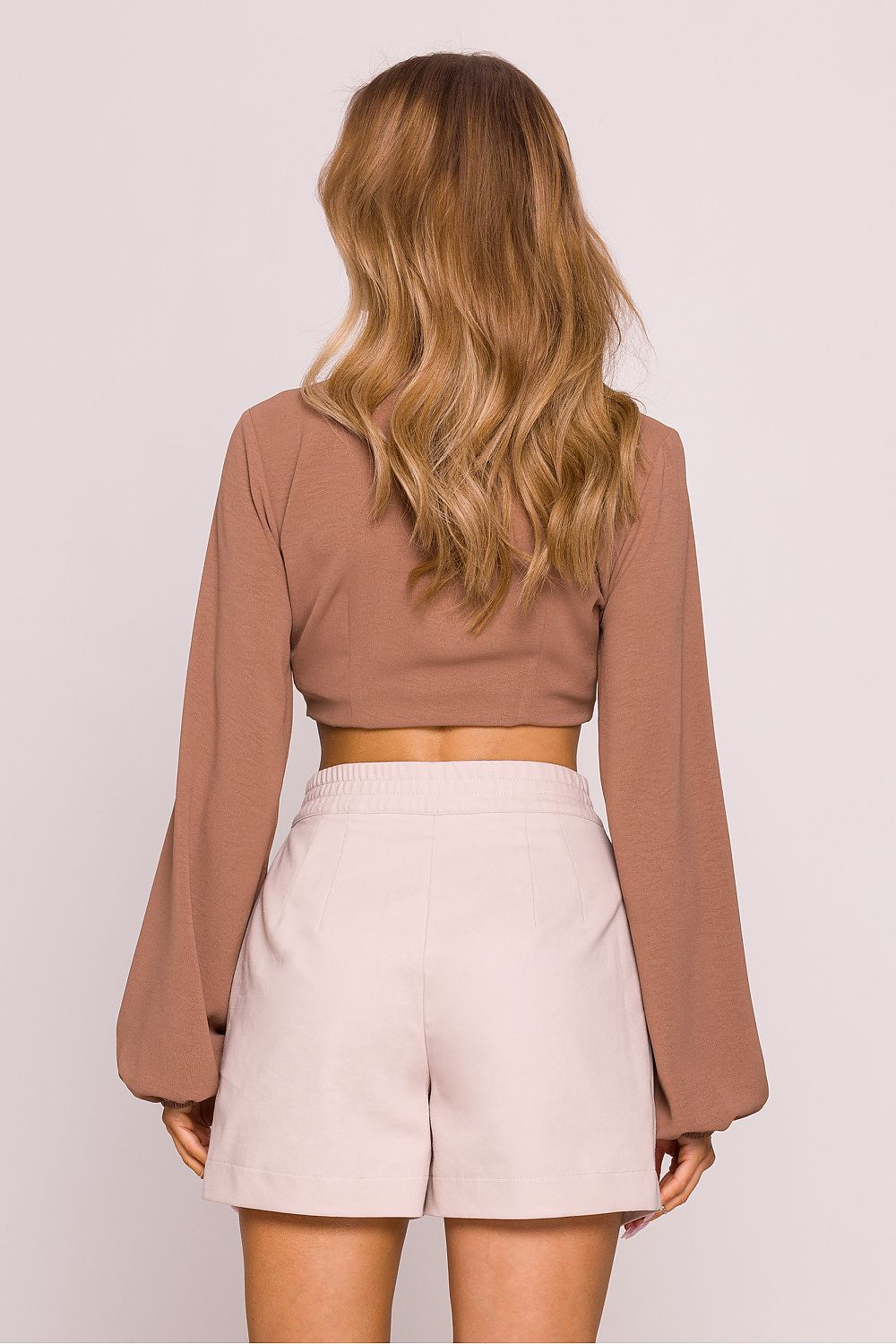 Rear view of high-waisted cotton shorts by Moe, designed in Poland, highlighting functional inset pockets and sophisticated silhouette.