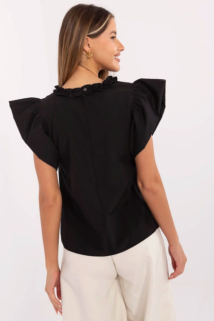 Close-up view of the Lakerta polka dot blouse featuring a feminine round neckline and charming frill accents.