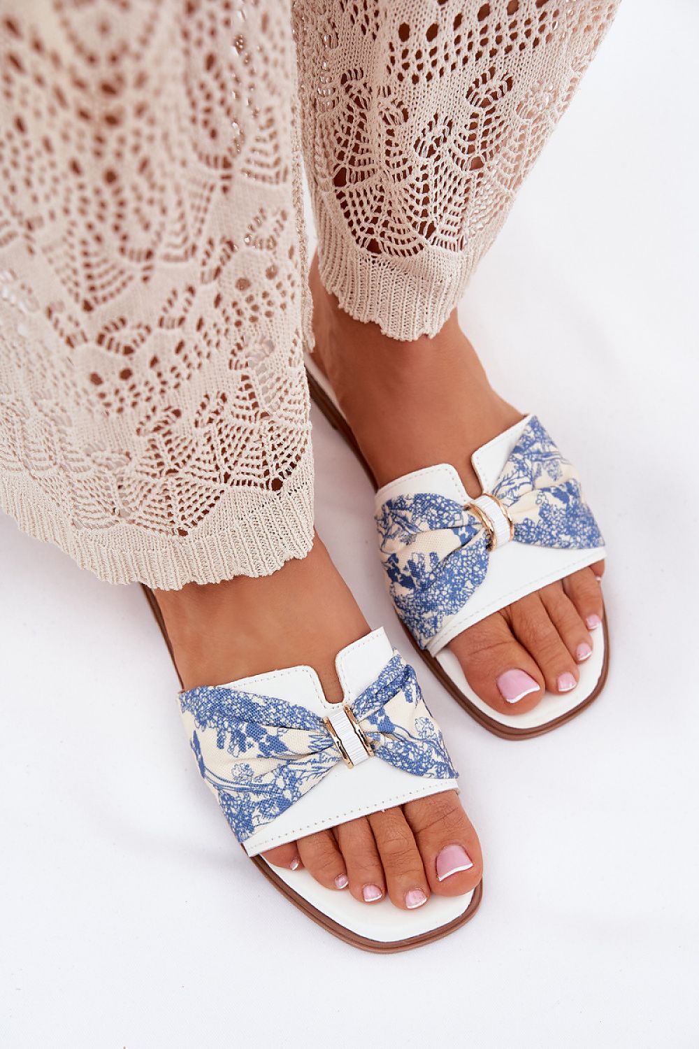 Model wearing Step in style women's sandals with a charming bow, showcasing versatility for dresses and shorts.