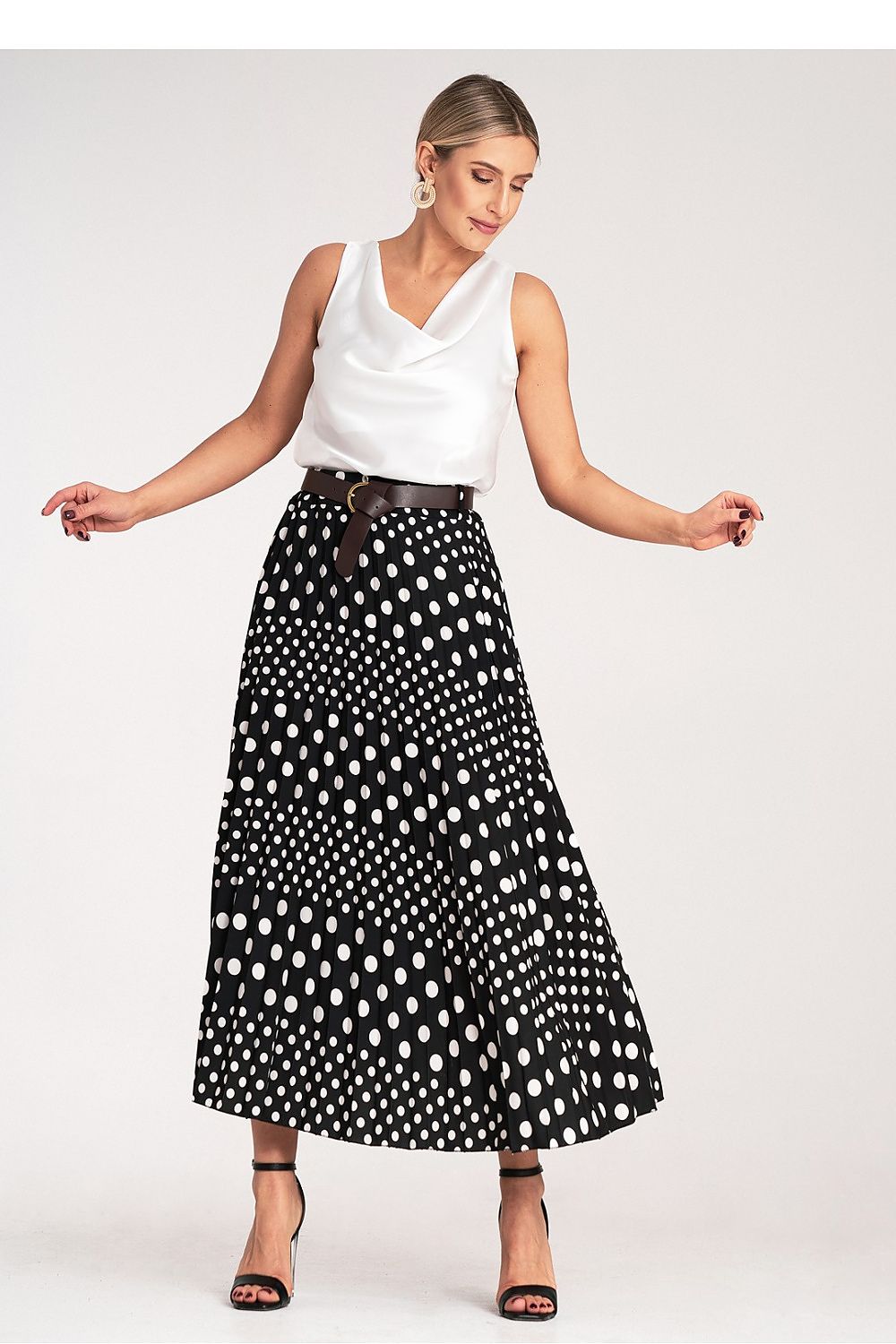 Side view of Figl's elegant pleated midi skirt in high-waisted style, adorned with white polka dots, ideal for adding a touch of luxury to any wardrobe.
