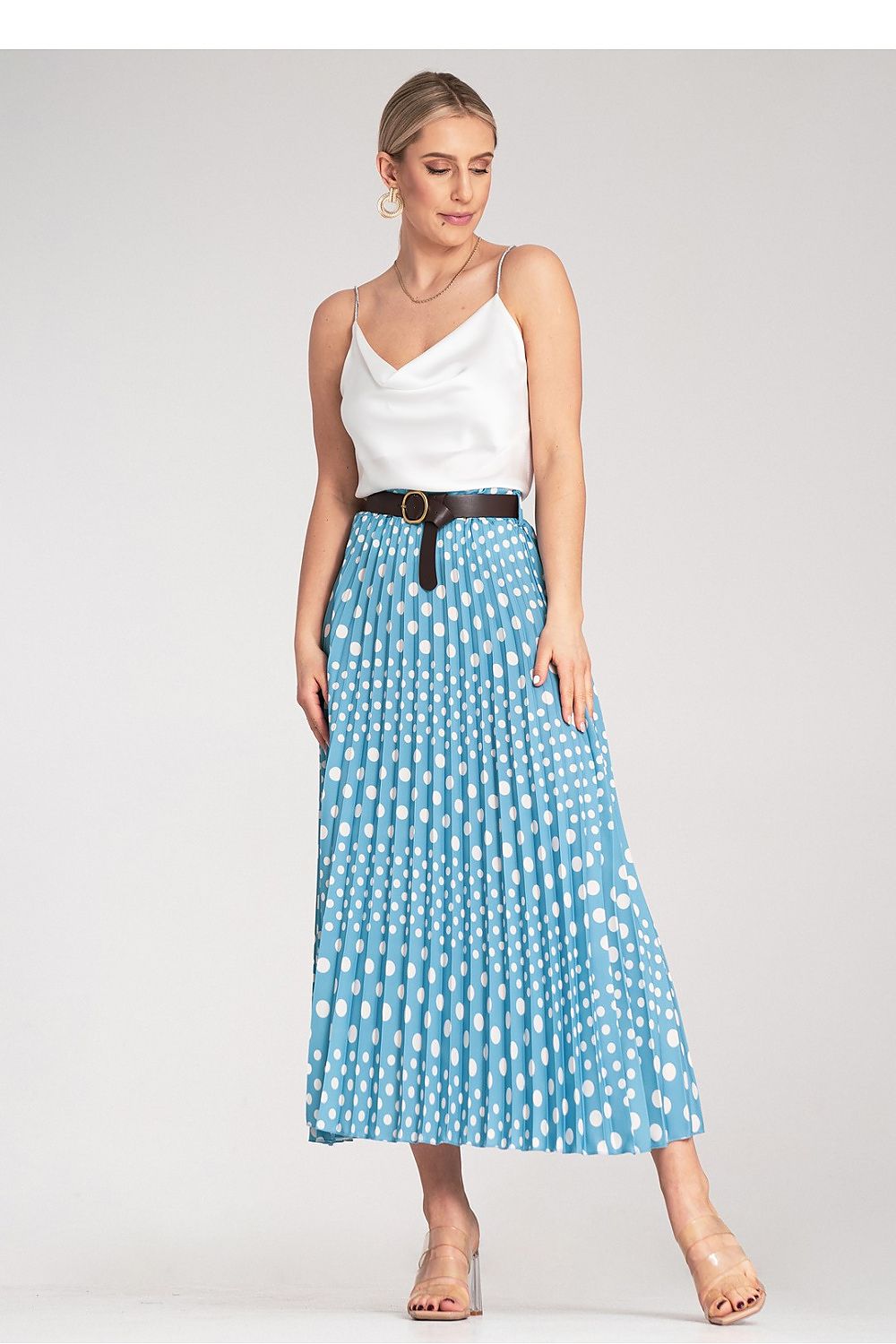 Model wearing Figl's elegant pleated midi skirt with white polka dots, styled for formal occasions, emphasising the high-waisted design and overall luxurious appeal.