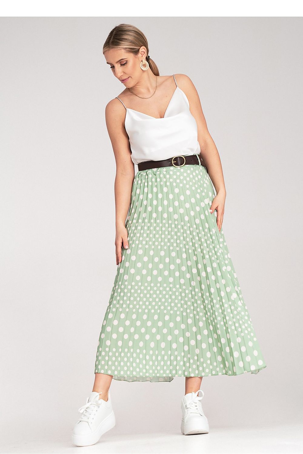 Close-up of Figl's elegant pleated midi skirt with white polka dots, highlighting the stylish belt and fabric texture.