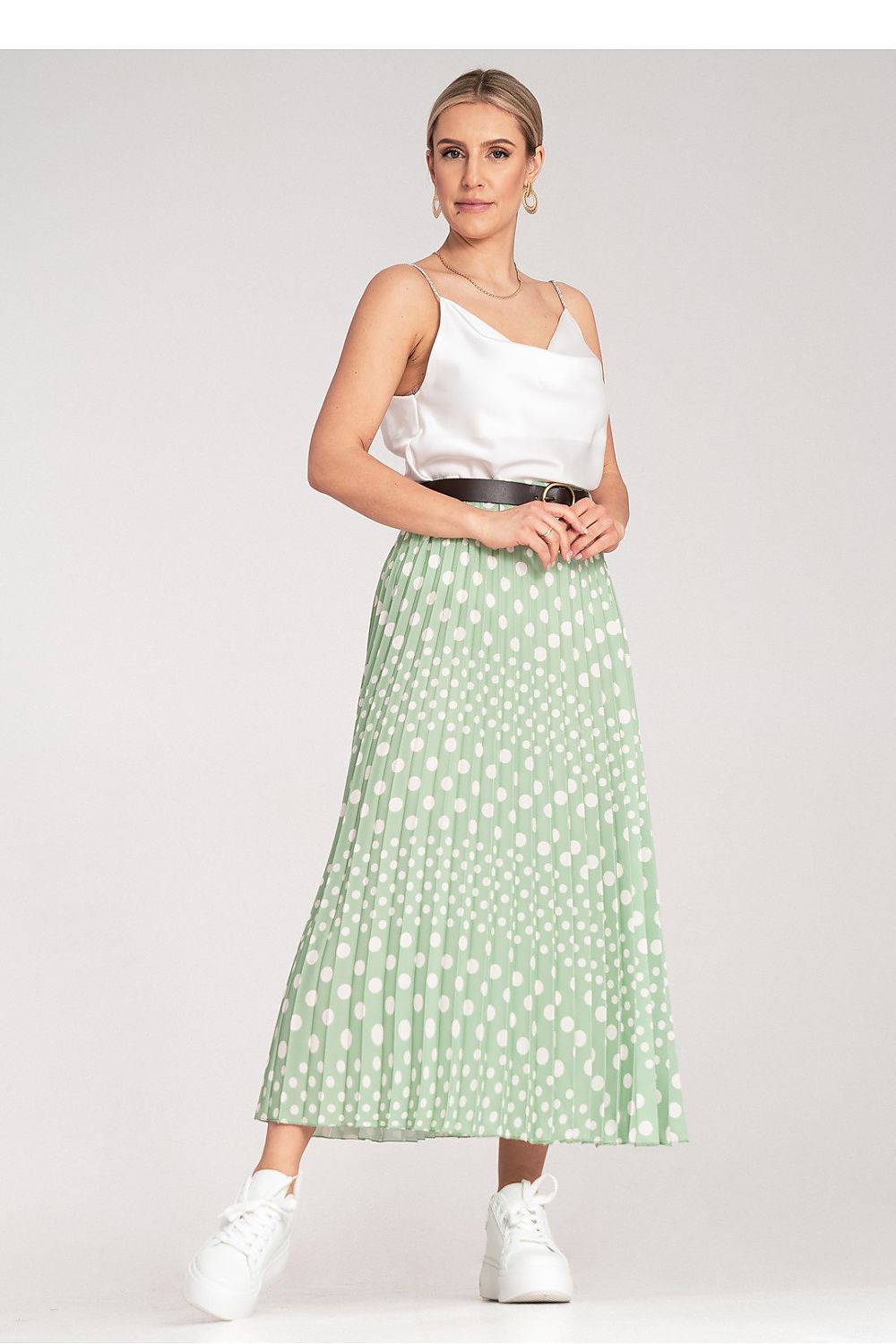 The Figl high-waisted pleated midi skirt styled elegantly, featuring white polka dots, ideal for chic outfits.
