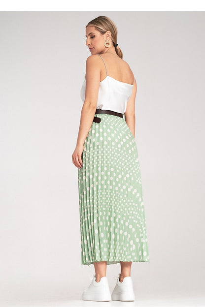 Side view of Figl's pleated midi skirt with white polka dots, demonstrating its flattering silhouette and waist accentuation.