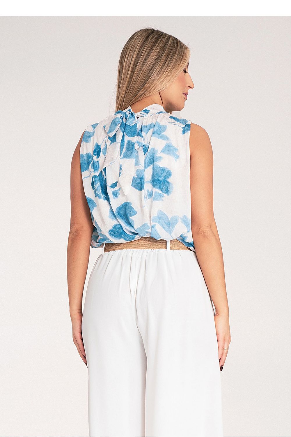 Chic Figl blouse in sleeveless style, designed with a fashionable tied neck and elastic hem, ideal for stylish layering.