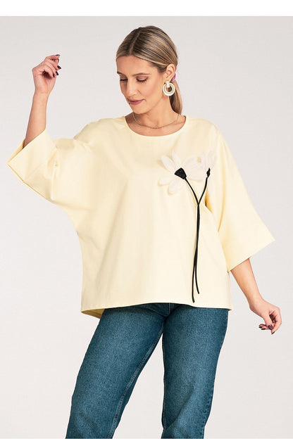 Close-up view of Figl's luxurious kimono blouse showcasing decorative flowers on the chest, crafted from a cotton-blend fabric for a chic look.