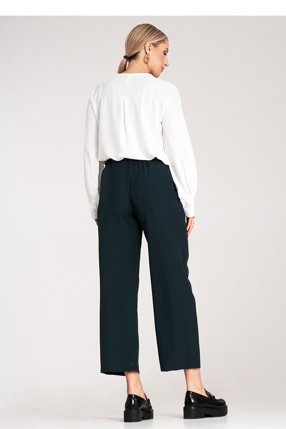 Model wearing luxurious high-waisted 7/8 trousers by Figl, styled with delicate pleats for an elegant look.