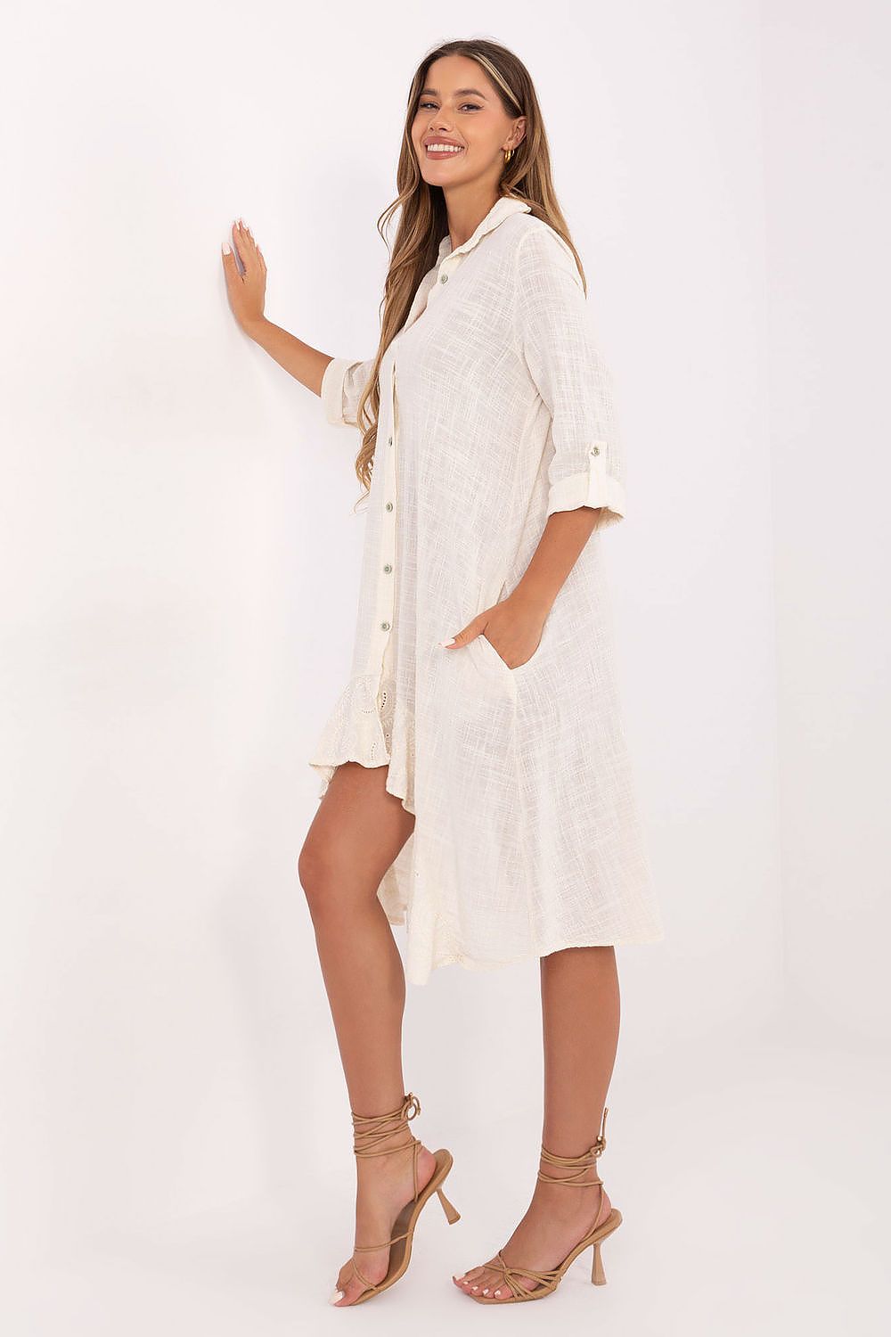 Model wearing Och Bella's asymmetrical cotton summer shirt dress styled for daytime outings, featuring practical side pockets and a classic collar.