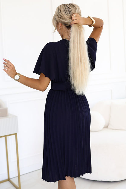 Close-up of the LYRA Daydress by Numoco highlighting its pleated bottom and luxurious fabric details, ideal for adding a touch of elegance to any wardrobe.