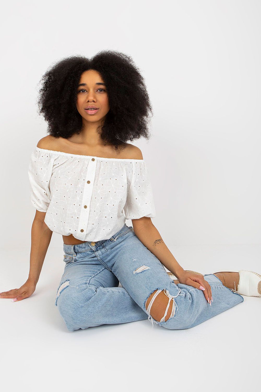 Elegant Lakerta off-the-shoulder boho blouse in luxurious white cotton with intricate lace embroidery, designed for a feminine summer look.