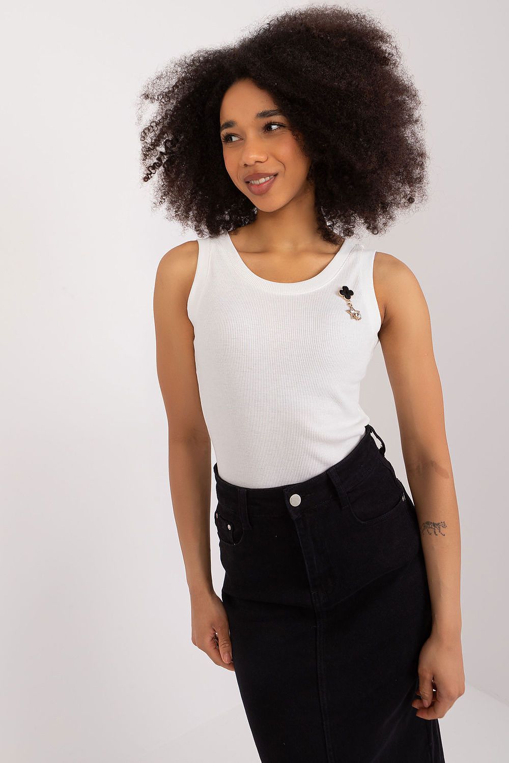 Detail view of the elegant brooch on Lakerta's sleeveless ribbed top, adding a touch of sophistication.