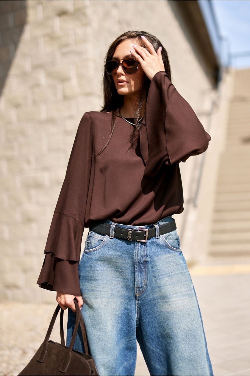 The elegant Camila Blouse by Roco Fashion, showcasing unique flounce sleeves made of lightweight viscose, in a chic setting.