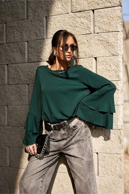 Model wearing the Camila Blouse by Roco Fashion, styled with fabric trousers for a sophisticated, luxurious look.