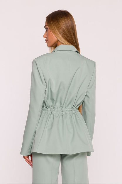 Elegant women's oversized blazer in sophisticated setting, showcasing adjustable waist detail from Moe for a tailored silhouette.