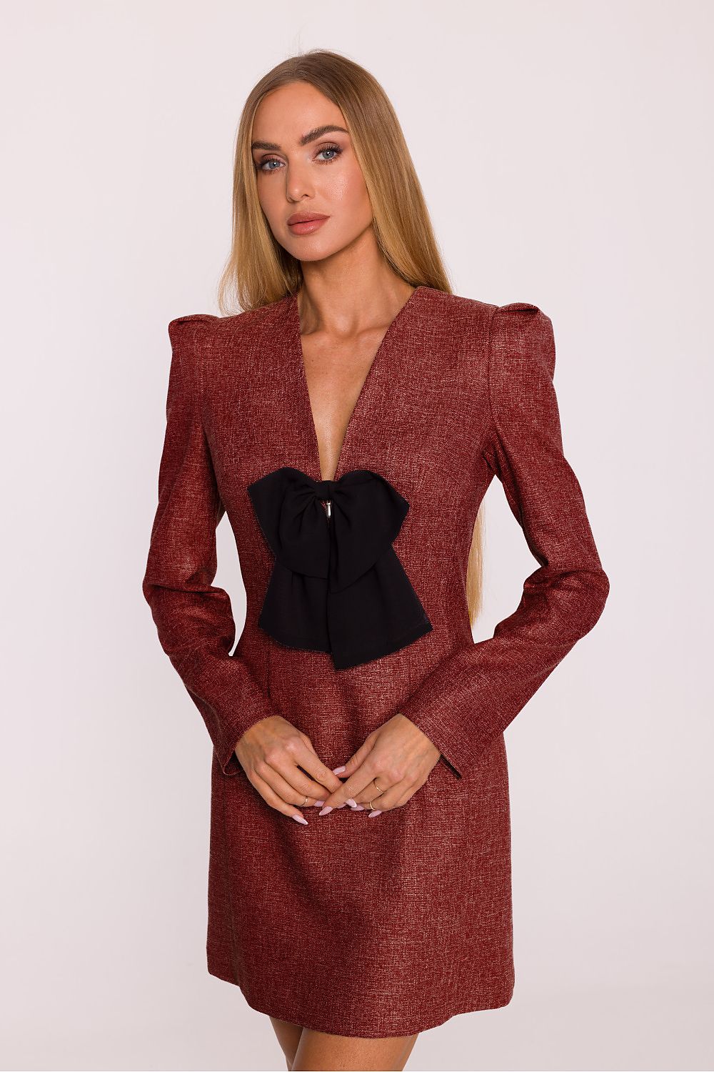 Close-up of the decorative brooch on Moe's elegant tweed daydress, showcasing an exquisite jewelry pendant accenting the modern classic design.