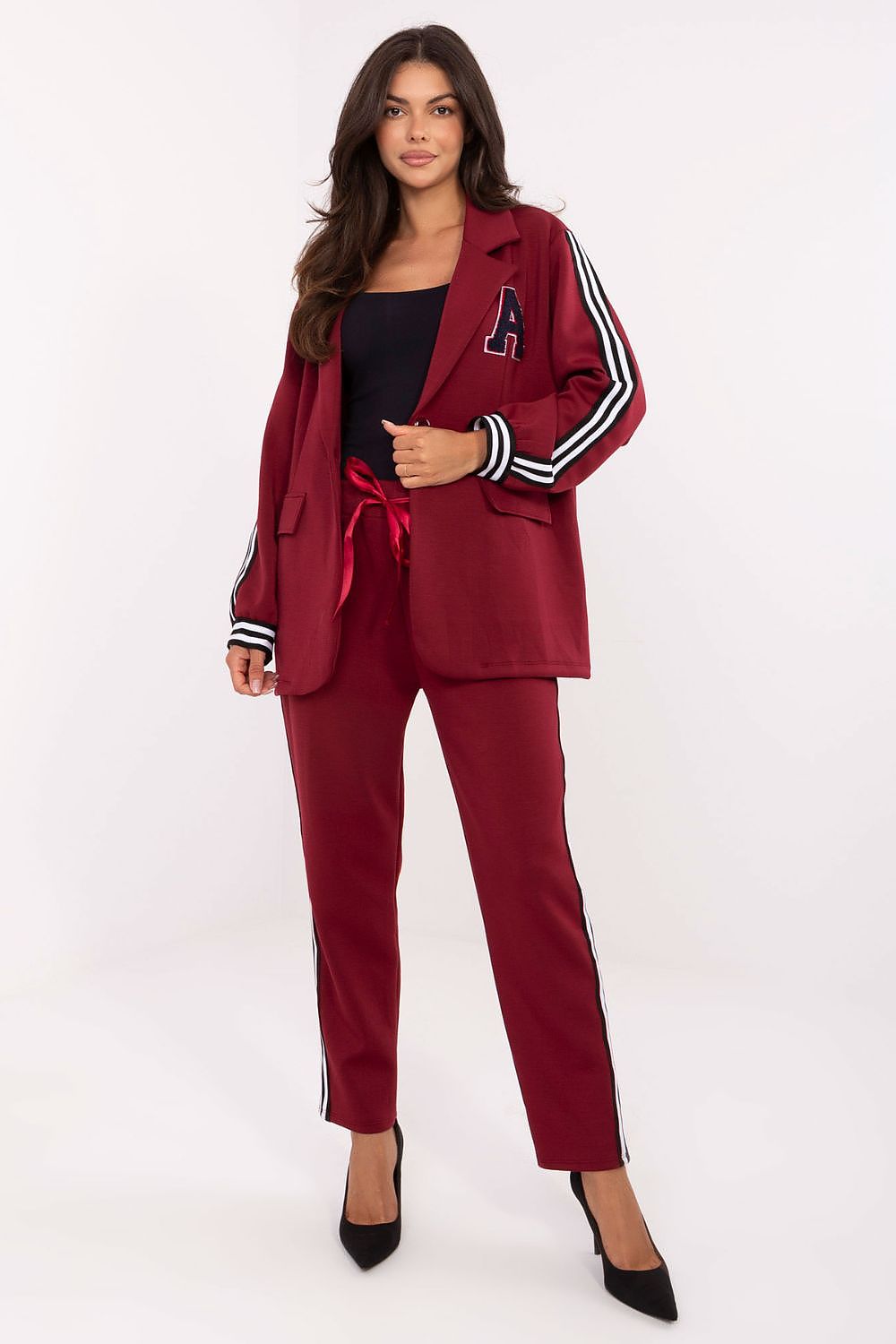 Model showcasing the luxurious women's buttoned jacket and tapered trousers from Rue Paris in a casual setting.