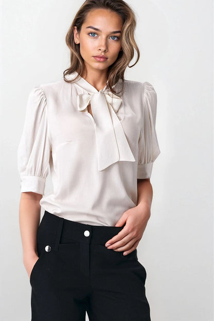 Nife blouse styled with a flattering neck tie and puffy sleeves, exemplifying elegance in soft-office fashion with a comfortable viscose composition.