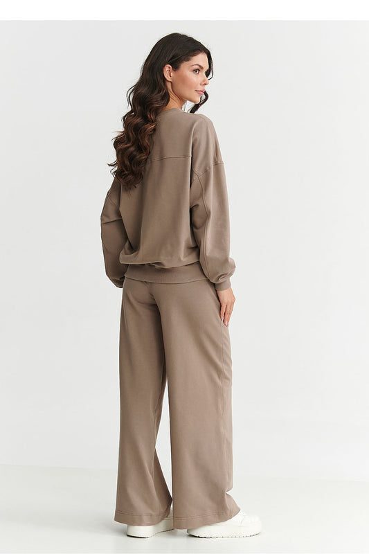 Luxurious Makadamia women's tracksuit set featuring an embroidered logo, showcasing a stylish oversized sweatshirt and wide-legged pants in comfortable fabric, ideal for casual elegance.