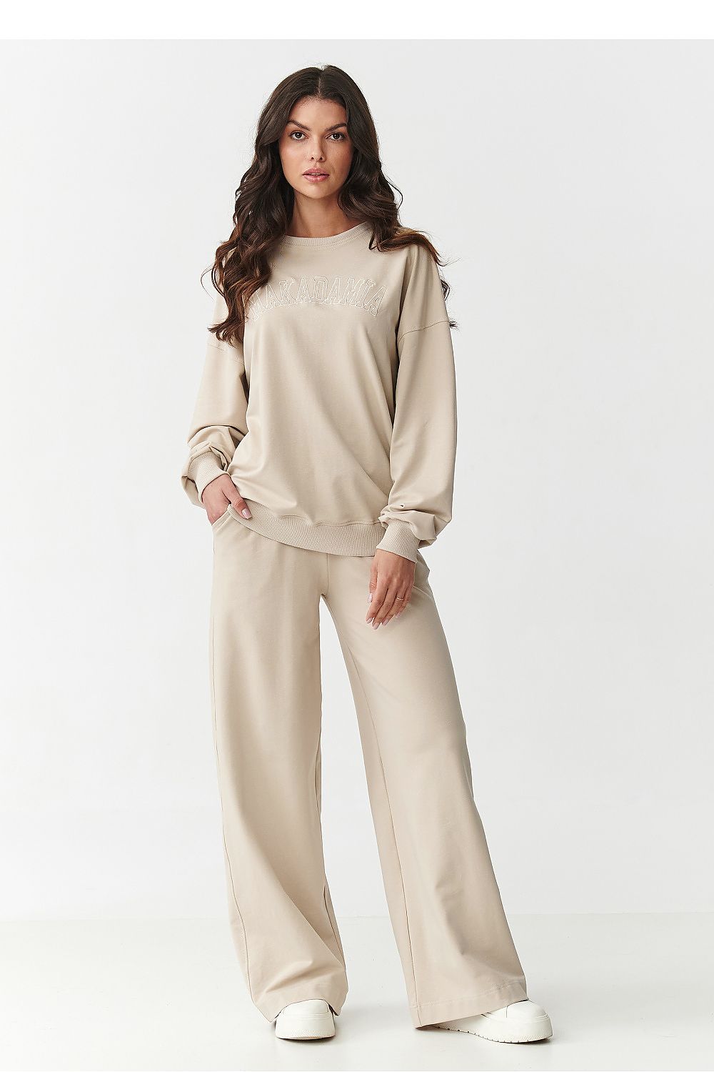 Close-up of Makadamia embroidered logo on a women's tracksuit sweatshirt, highlighting luxury design and attention to detail, perfect for elevated casual wear.