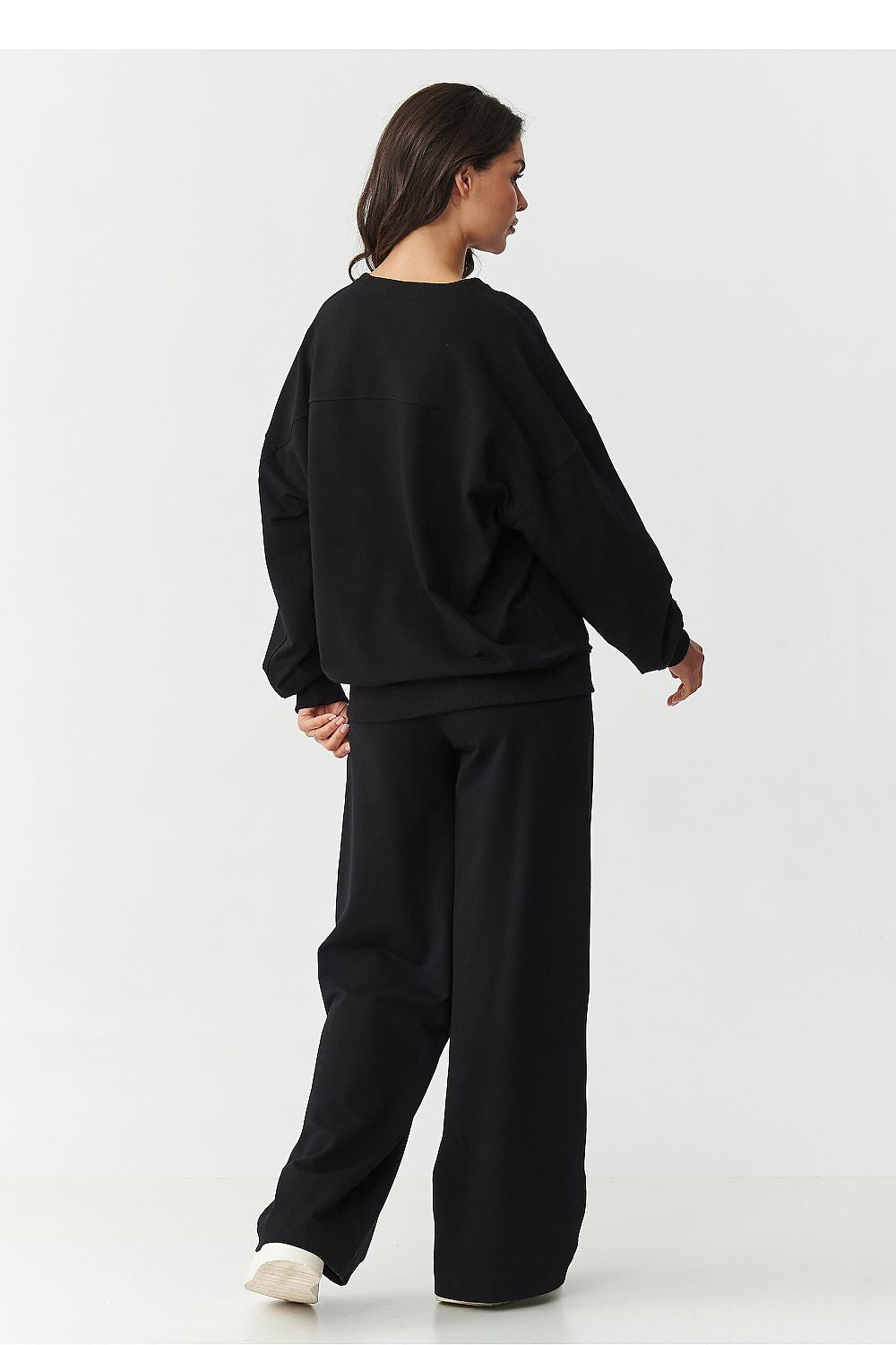 Model in motion wearing Makadamia's luxurious women's tracksuit with wide-legged pants, capturing the flow and elegance of the outfit, ideal for casual or chic occasions.