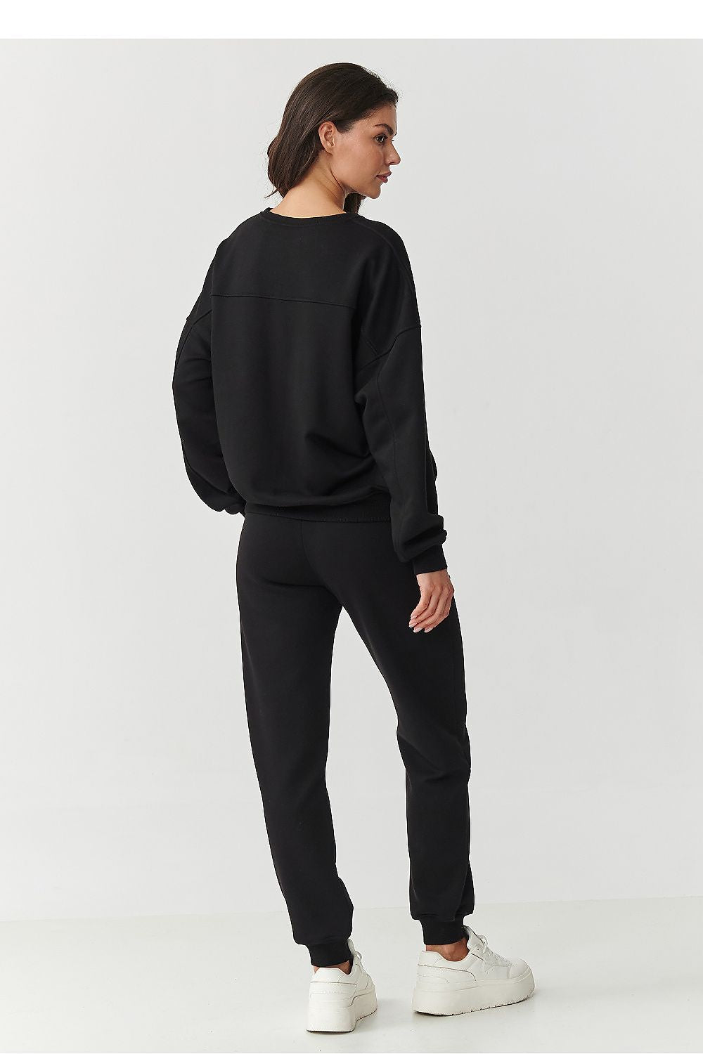 Close-up view of Makadamia's luxury tracksuit sweatshirt, highlighting the premium cotton fabric and elegant embroidered logo.