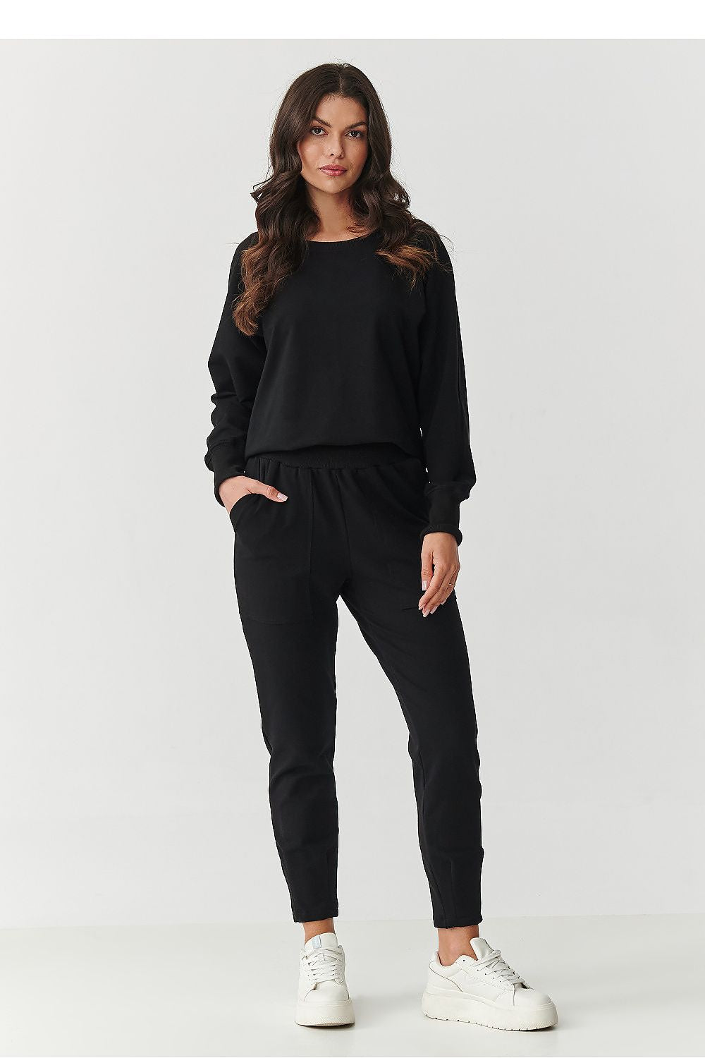 Makadamia luxury women's tracksuit, highlighting the practical large pockets and slight narrowing leg seams, combining functionality with style.