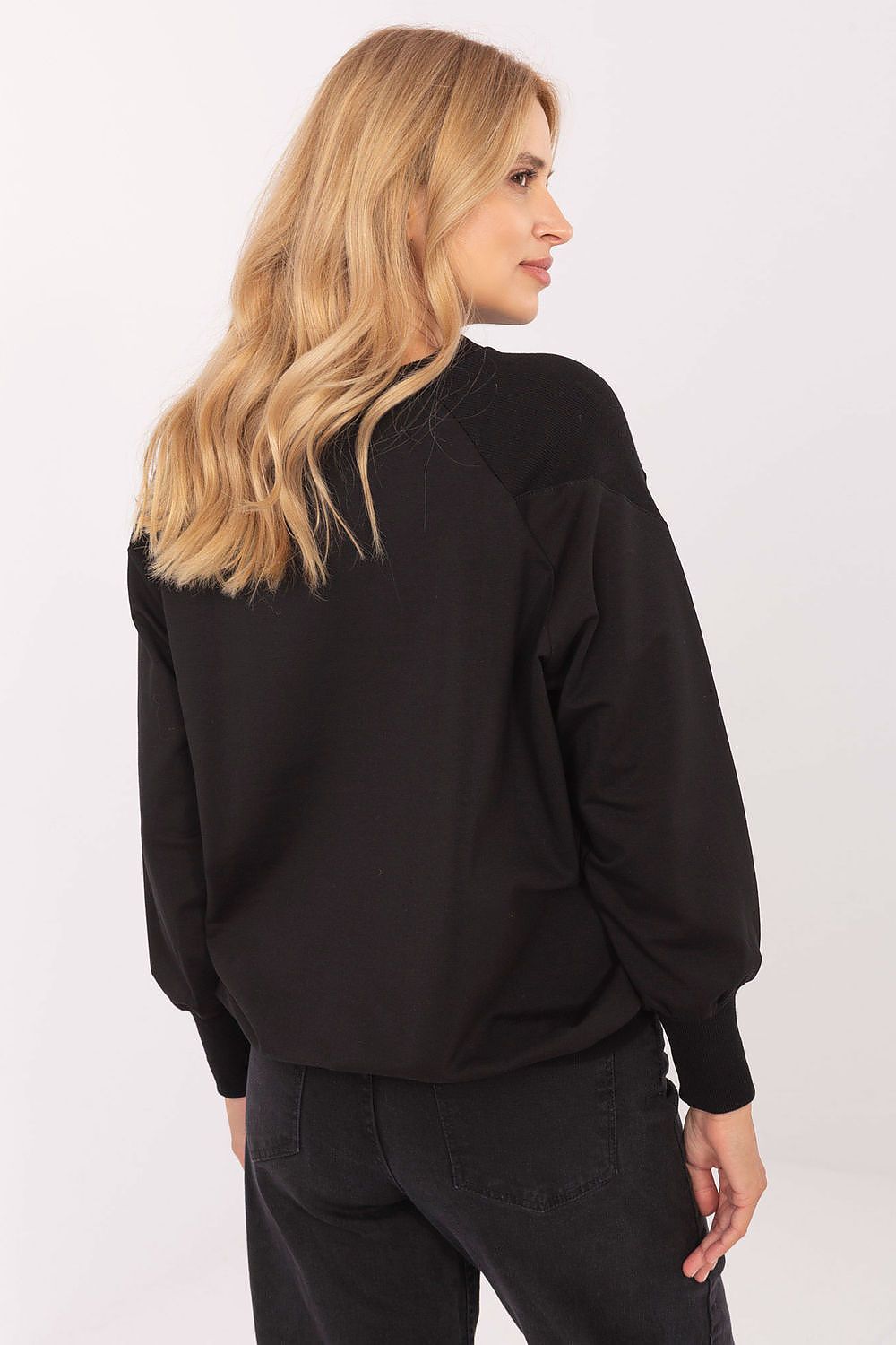 Close-up of elegant women's casual blouse detailing, featuring fashion-forward studs and a chic adjustable tie at the bottom, crafted by Relevance in a comfortable cotton and spandex blend.