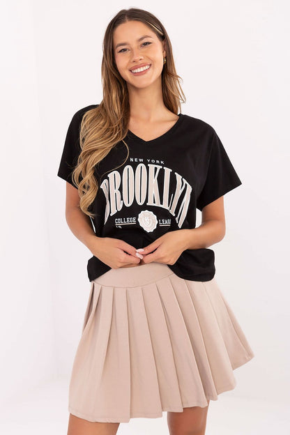 Luxurious V-neck t-shirt crafted from soft cotton by Relevance, designed to complement the pleated mini skirt in a trendy casual outfit.