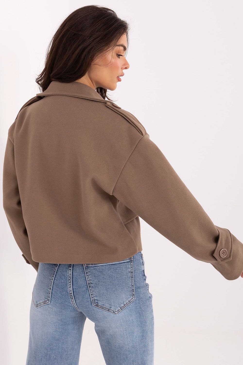 Model showcasing a short trench coat by Rue Paris made of eco-leather, designed for versatility and everyday elegance in urban fashion.