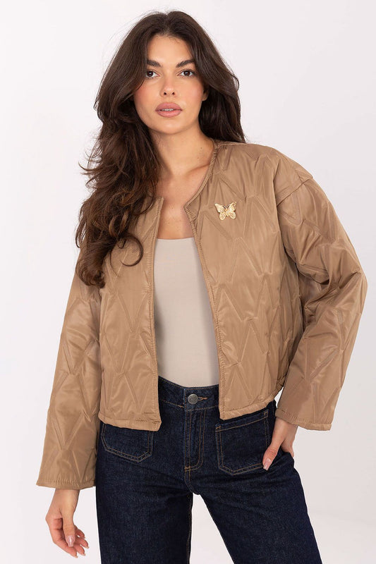 Elegant women's quilted jacket by Rue Paris featuring a butterfly brooch, perfect for transitional autumn and spring outfits.