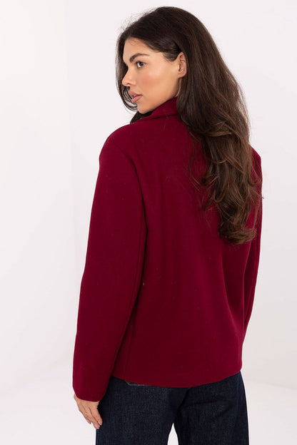 Model wearing Rue Paris's elegant women's coat paired with chic trousers, illustrating the timeless style suitable for various occasions.