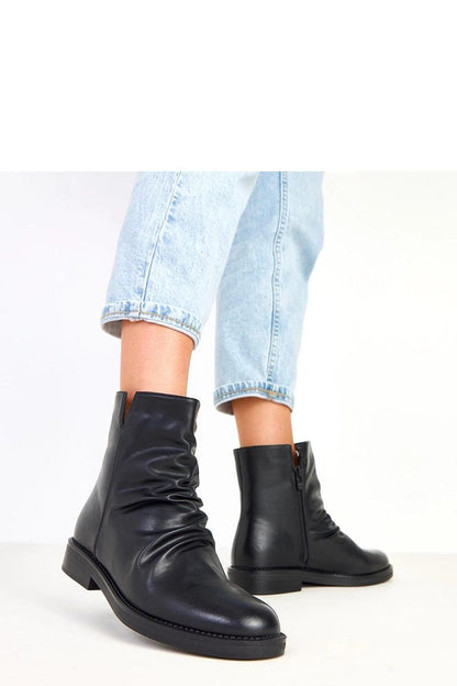 Solea Women's Classic Ankle Boots placed stylishly to highlight their versatile black eco-leather finish, perfect for casual or elegant outfits.