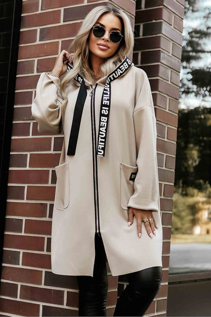 Elegant luxury beige hooded women's coat from Numoco Basic, showcasing practical pockets and a stylish design.