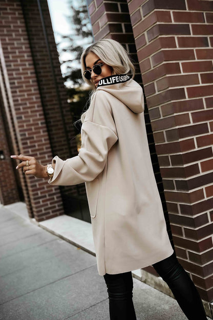 Fashionable beige hooded coat by Numoco, featuring a comfortable loose cut and modern drawstrings, perfect for everyday elegance.