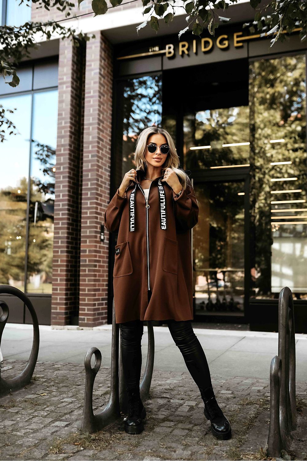 Luxury beige hooded women's coat by Numoco, featuring an elegant design and practical pockets, perfect for stylish cold-weather outfits.