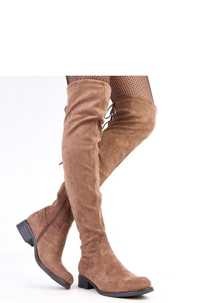 Stylish Solea over-the-knee suede boots worn in an urban setting, embodying luxury and warmth for winter.