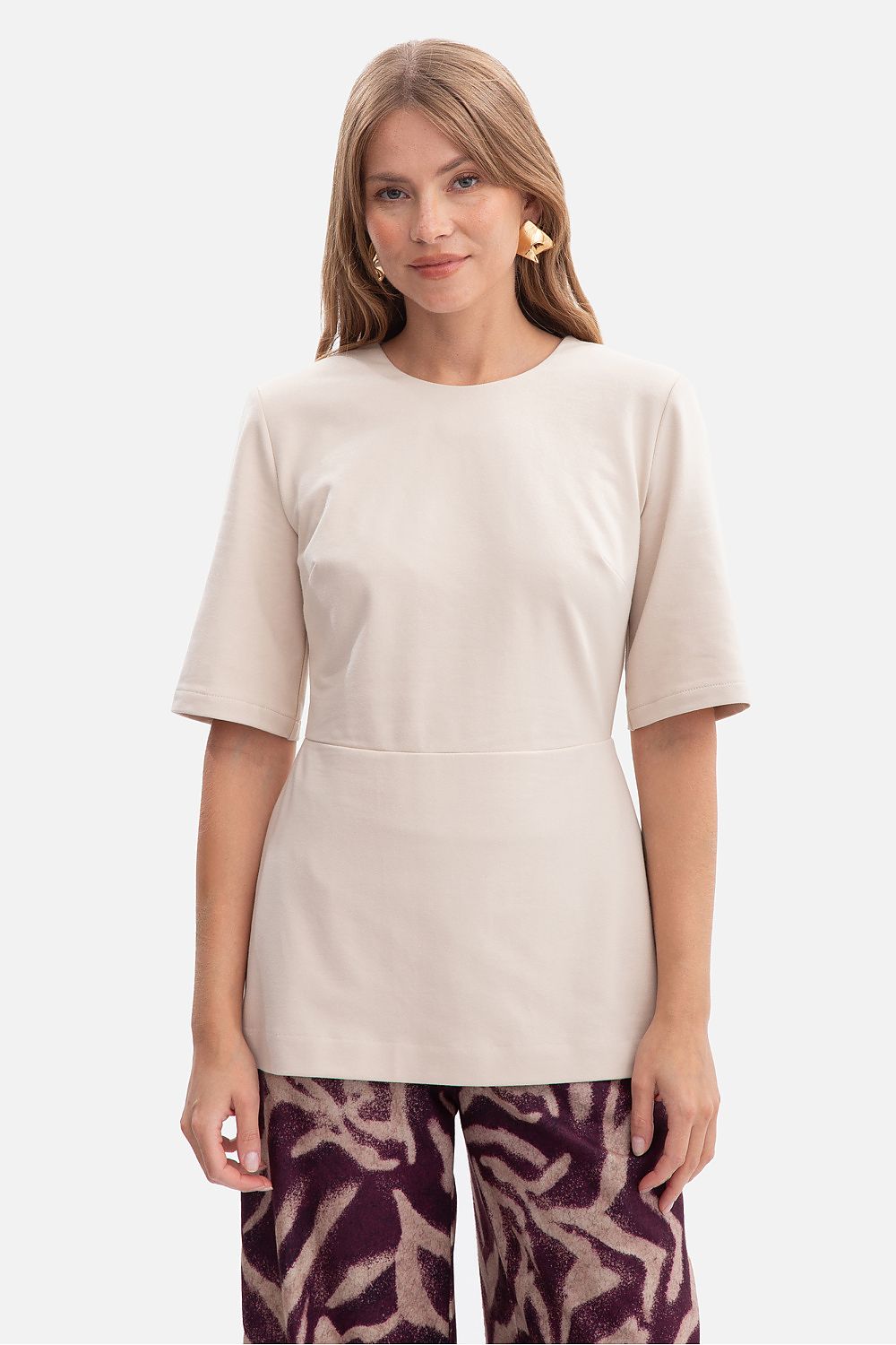 Elegant BeWear blouse featuring a flared peplum, crafted from smooth cotton and spandex blend, embodying luxury and comfort.