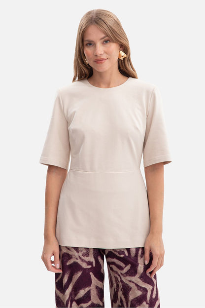 Elegant BeWear blouse featuring a flared peplum, crafted from smooth cotton and spandex blend, embodying luxury and comfort.