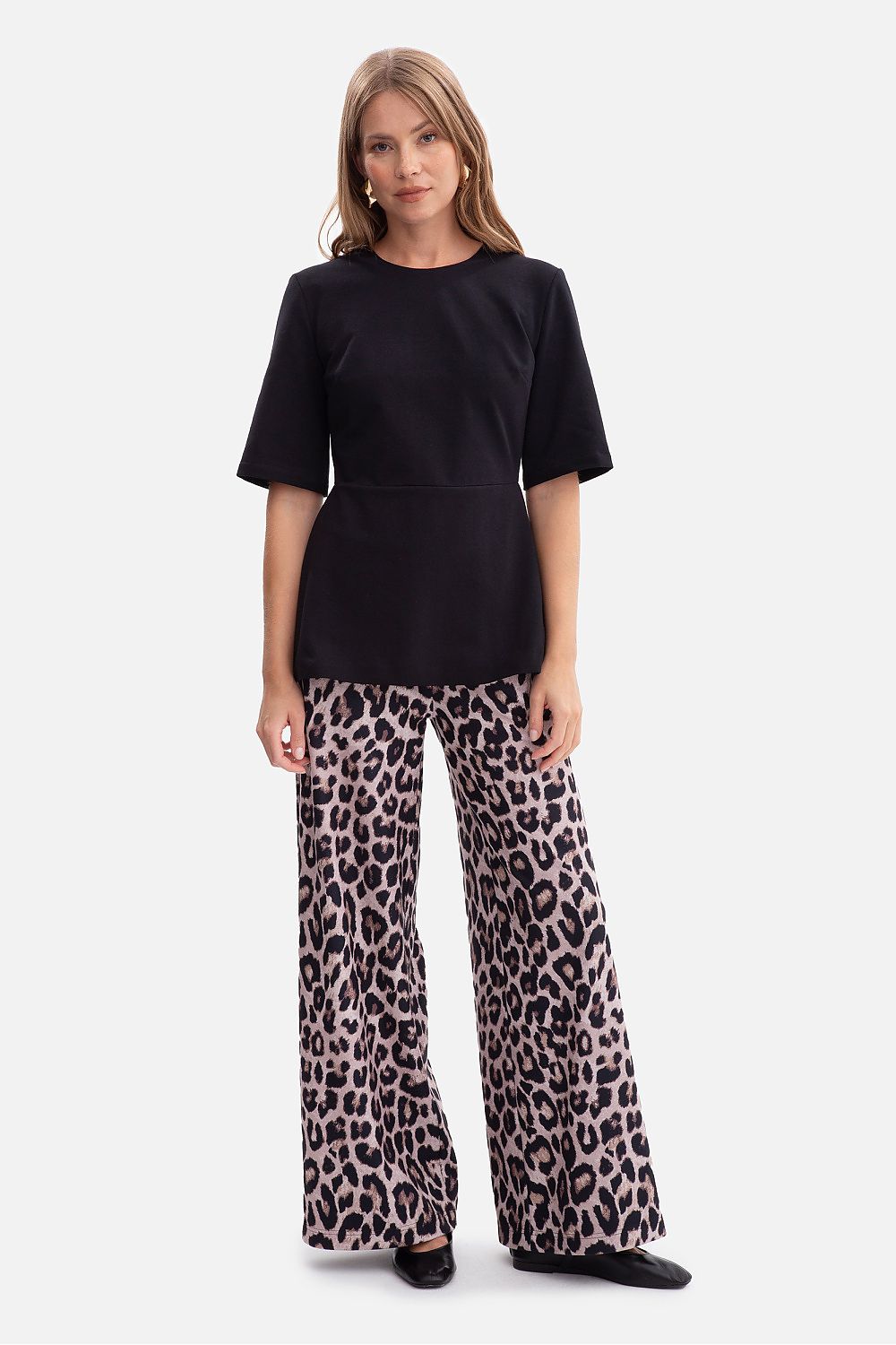 BeWear blouse displayed on a mannequin, highlighting the flared peplum and classic round neckline in a stunning outfit.