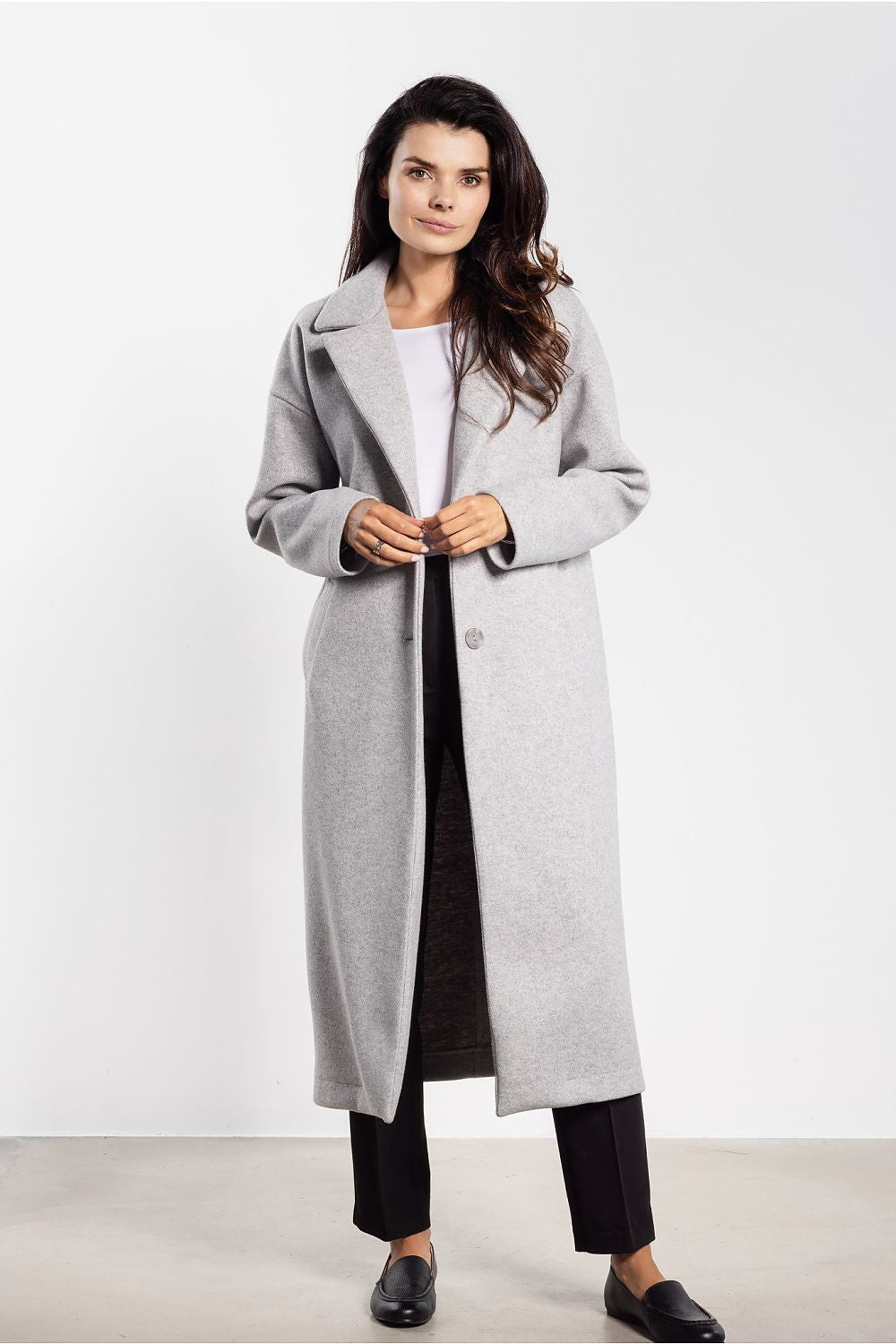 Elegant women's midi coat by awama, featuring a minimalist design and classic lapels, showcased in a luxurious autumn setting.