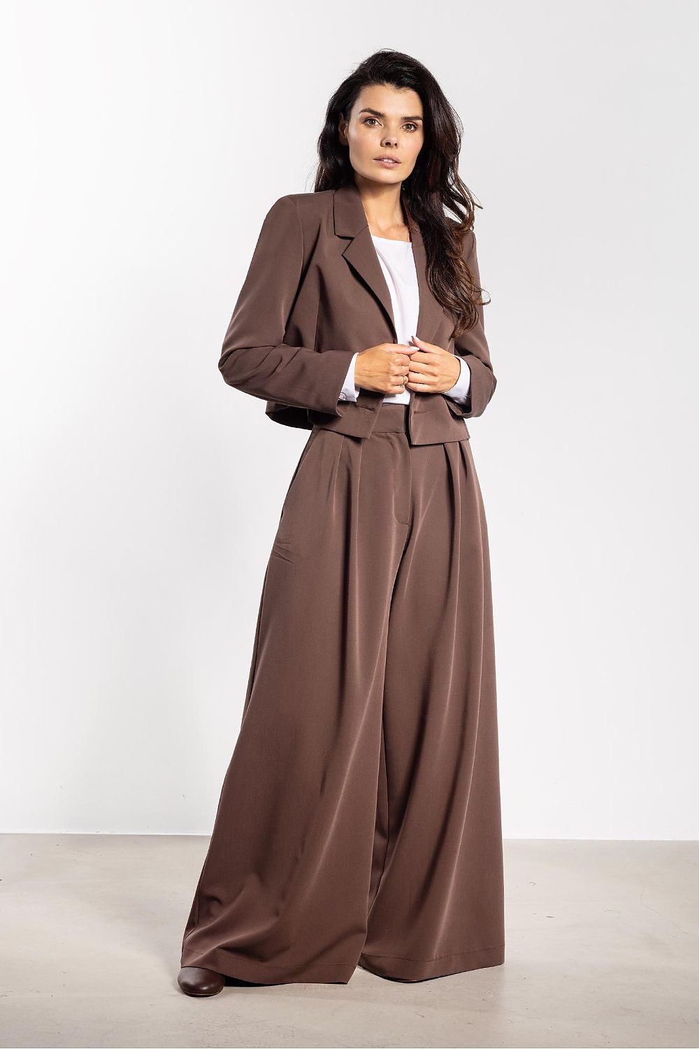 Model wearing Awama's elegant double-breasted jacket, styled with wide trousers for a modern and chic ensemble suitable for various occasions.